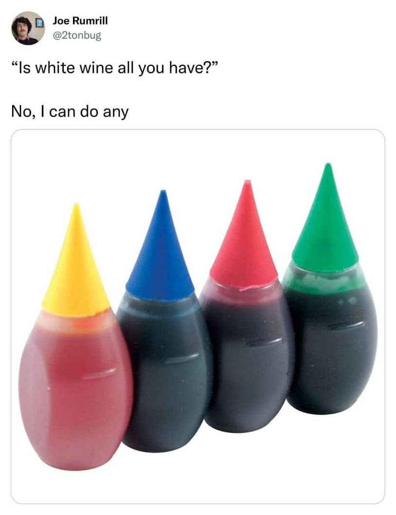 Four small bottles of food coloring standing in a row with yellow, blue, red, and green caps.