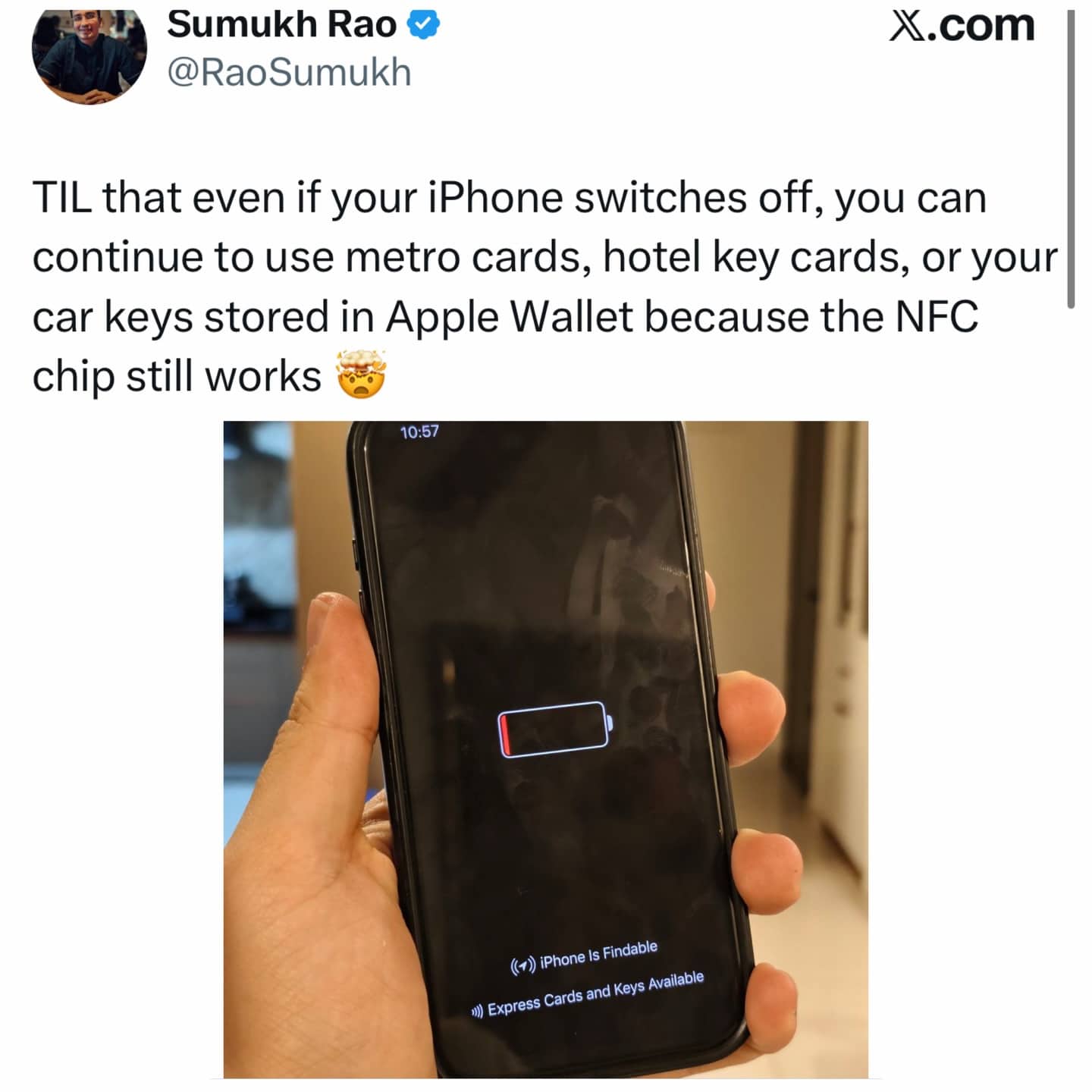 A hand holding an iPhone with a dead battery showing that Apple Wallet NFC still works.