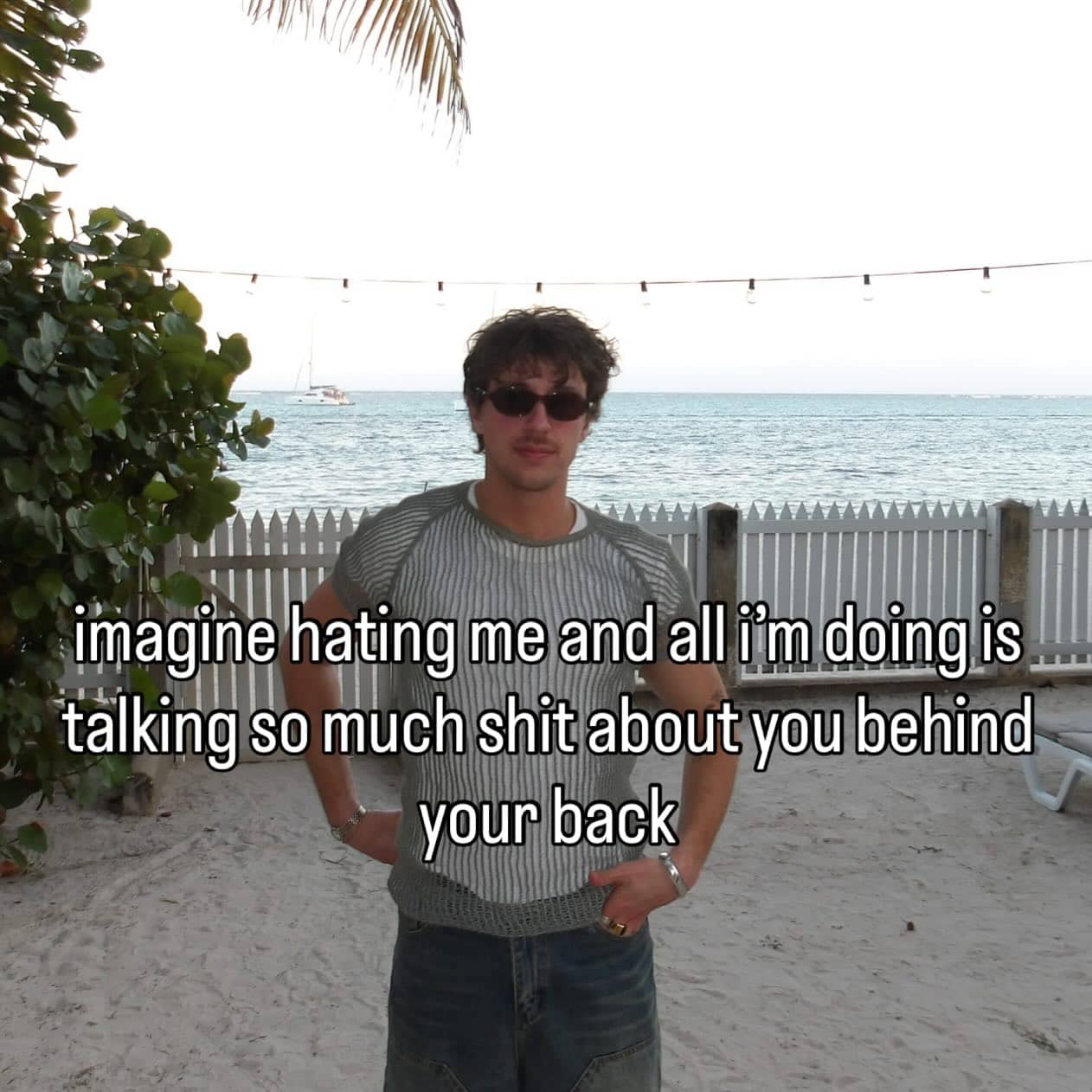Sarcastic meme of a man standing on a beach with text about talking behind someone's back.