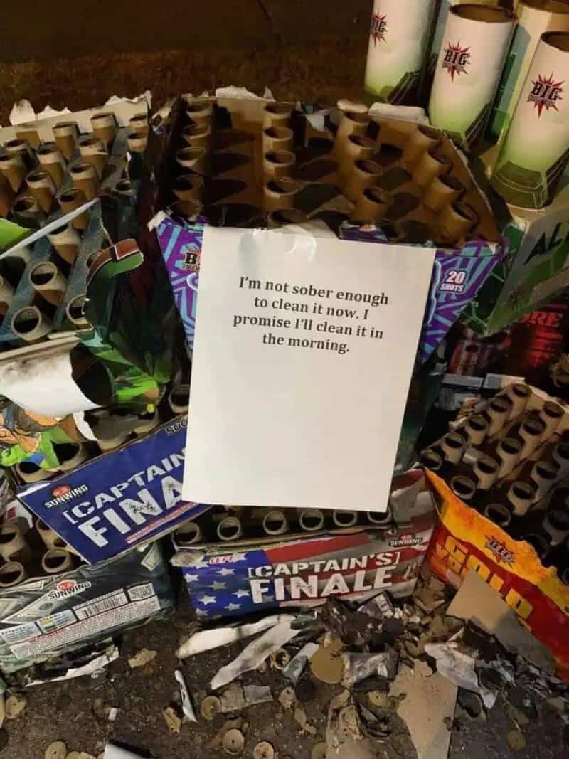 A large pile of spent fireworks with a note promising to clean them up in the morning.