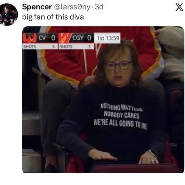 Woman at hockey game wearing a dark shirt that says nothing matters, nobody cares, we're all going to die.