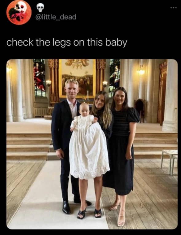 Optical illusion of a baby in a long white dress appearing to have adult legs.