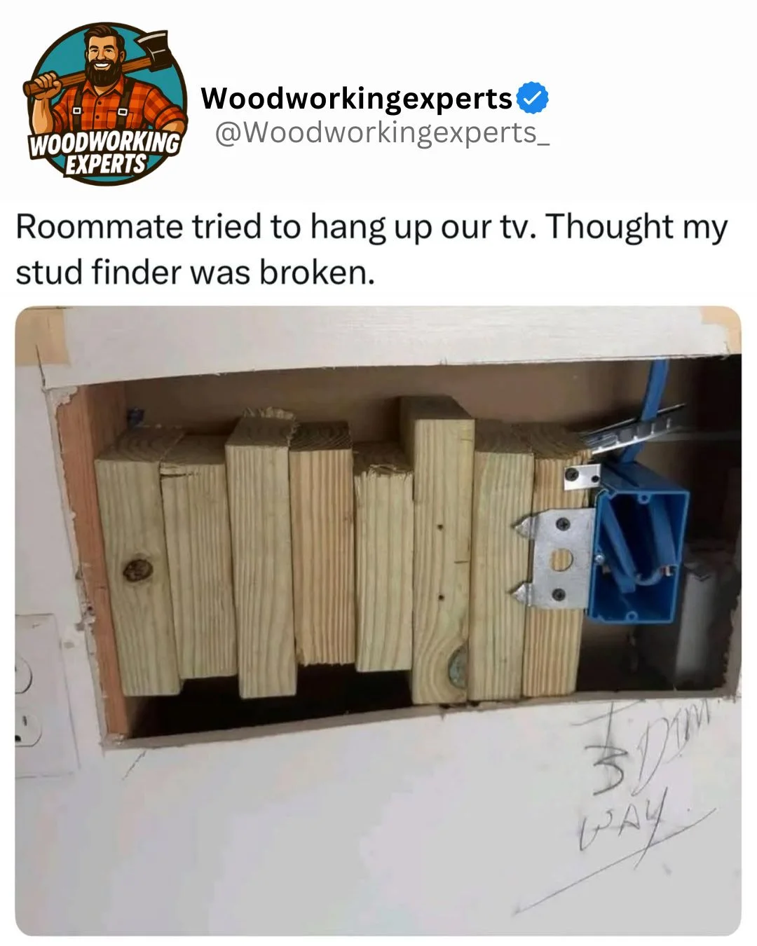 A hole in a wall revealing dozens of wooden studs packed tightly together.