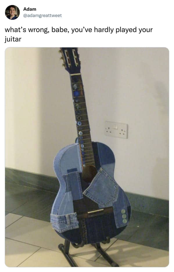Acoustic guitar covered entirely in denim patchwork standing in a room, humorously referred to as a juitar.