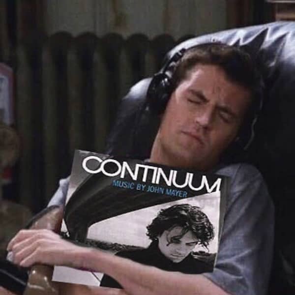 Friends character Chandler Bing hugging a John Mayer Continuum vinyl record while closing his eyes.