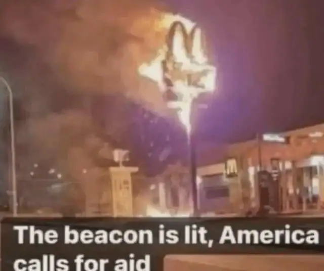 A lotr meme featuring a photo of a McDonald's sign engulfed in flames, captioned with the famous line The beacon is lit, America calls for aid.