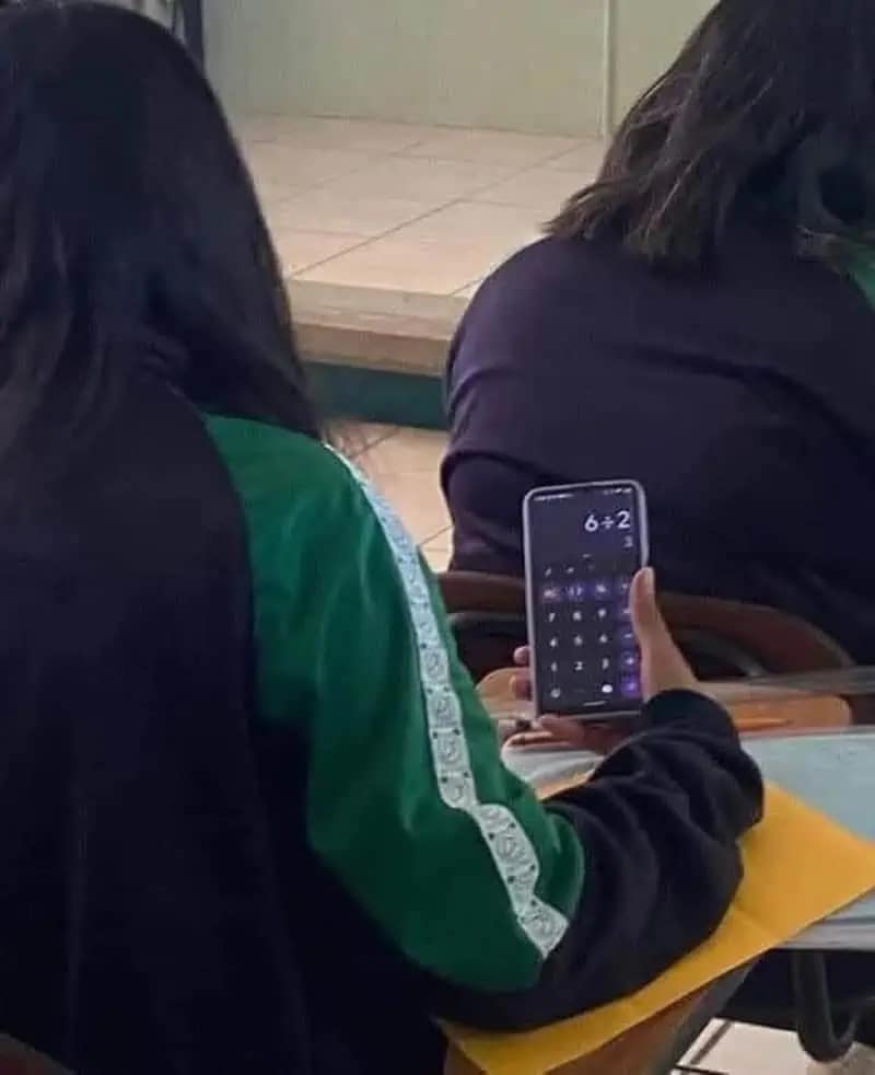 A meme dump photo of a student holding a smartphone with a calculator app open showing "6+2" during a math exam.