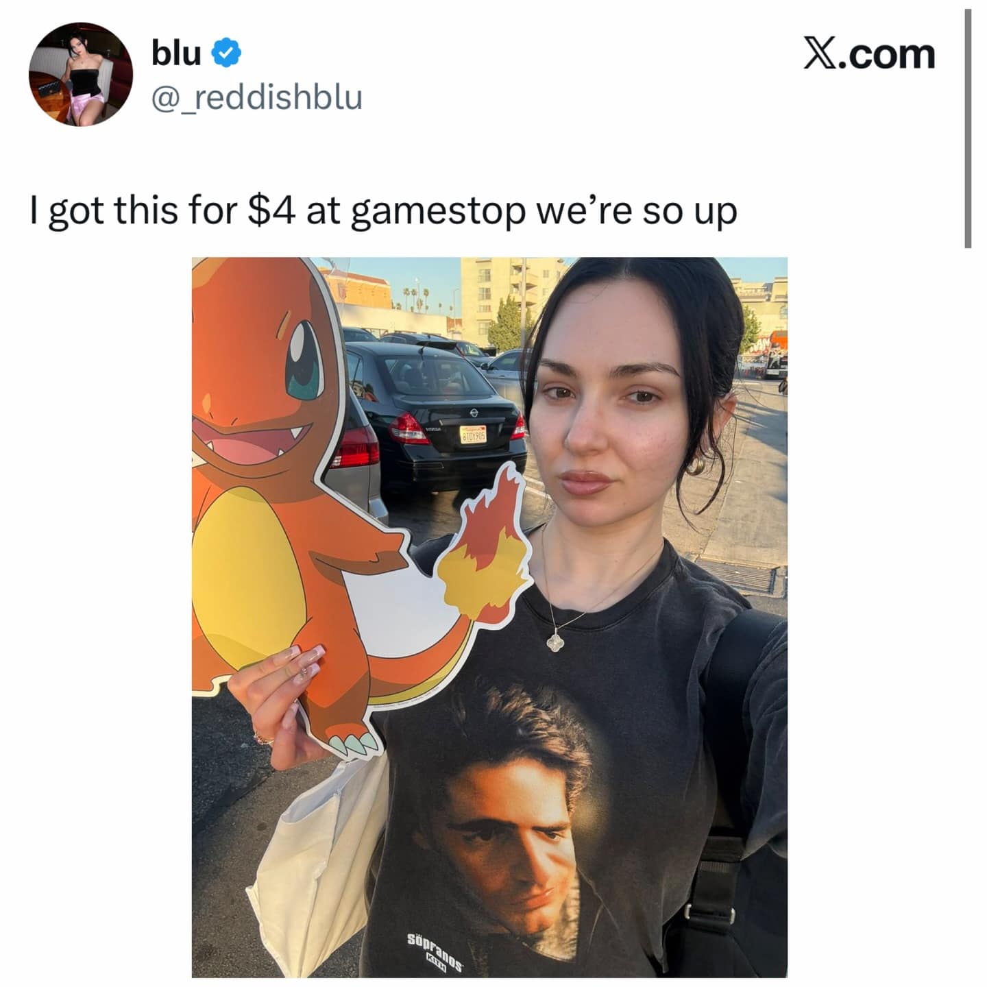 A funny meme showing a woman celebrating buying a giant cardboard Charizard cutout for $4 at GameStop.