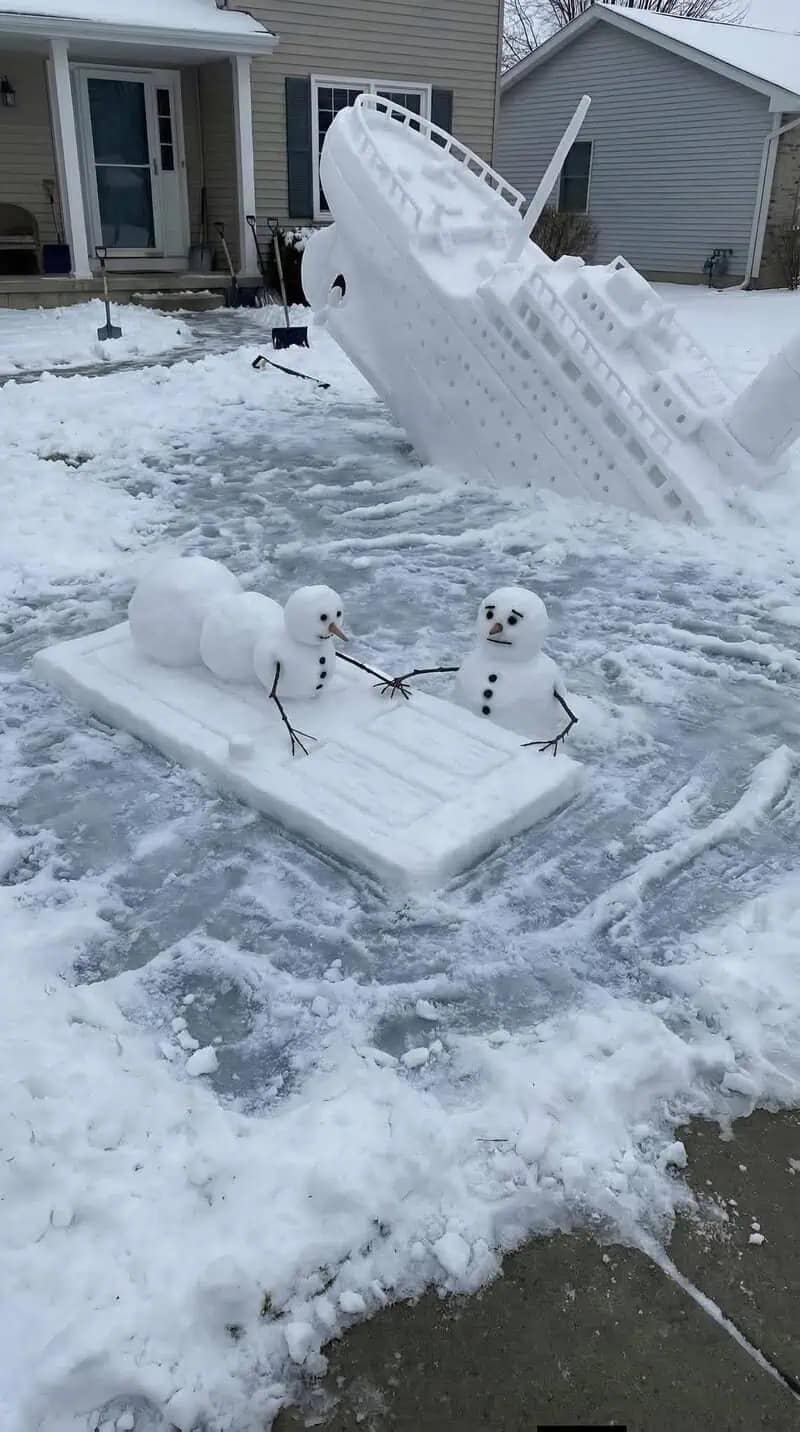 A hilarious meme photo of a snow sculpture recreating the sinking Titanic and the "door scene" in a front yard.