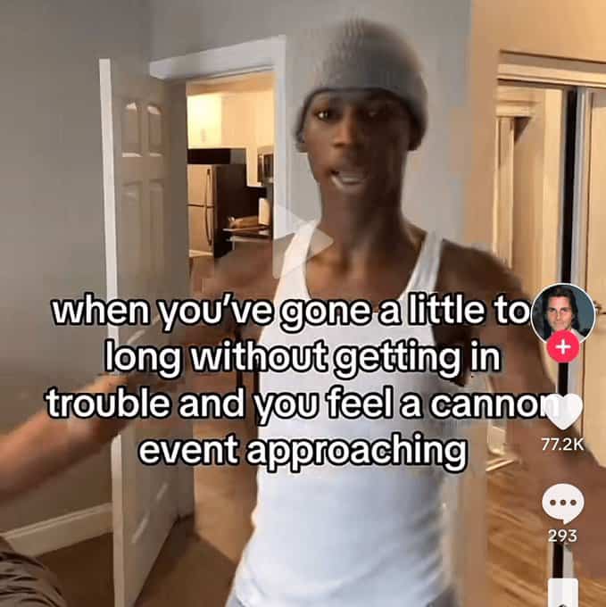 Man in a white tank top and beanie sensing an approaching "canon event" trouble.