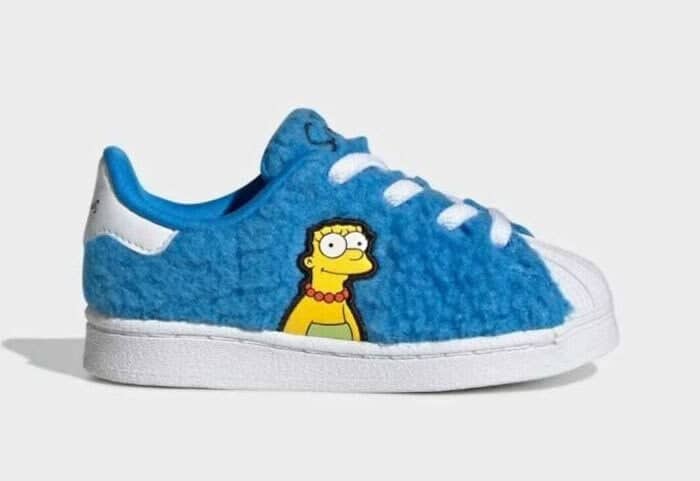 Blue fuzzy Adidas Superstar sneakers featuring an embroidered Marge Simpson with her tall blue hair covering the shoe.