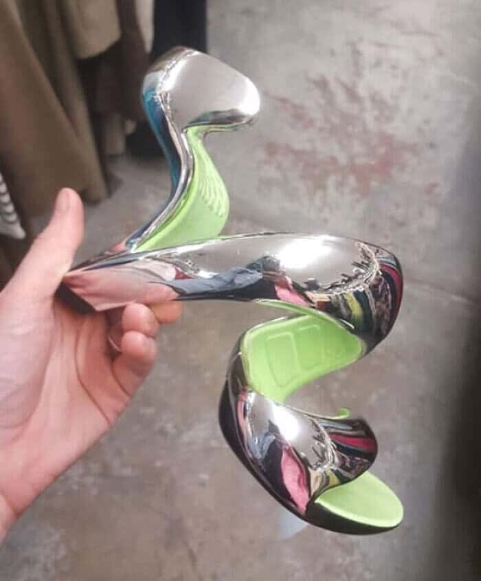 Silver chrome spiral high heel sandal with a lime green sole and no visible vertical heel support.