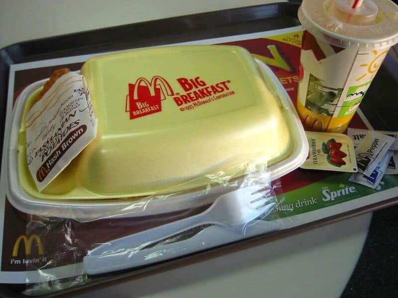 A vintage McDonalds image featuring a yellow Styrofoam Big Breakfast container, a hash brown, and a cup of Sprite.