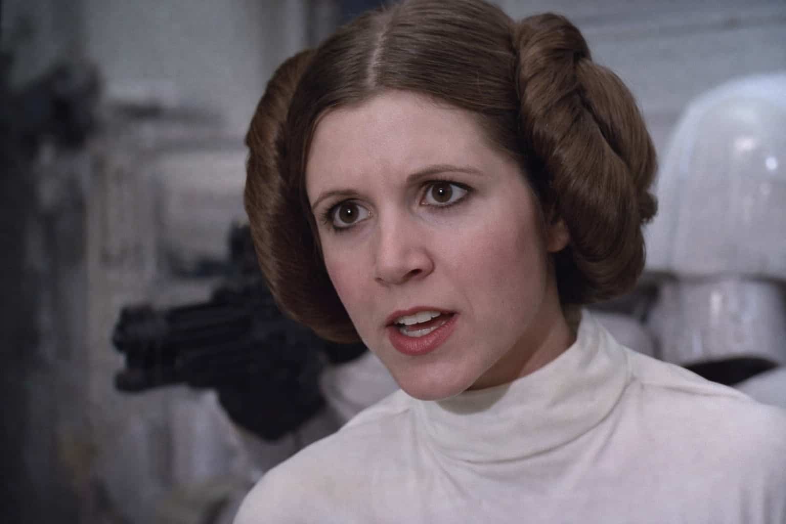Princess Leia with her iconic hair buns looking serious in a still for princess leia memes.