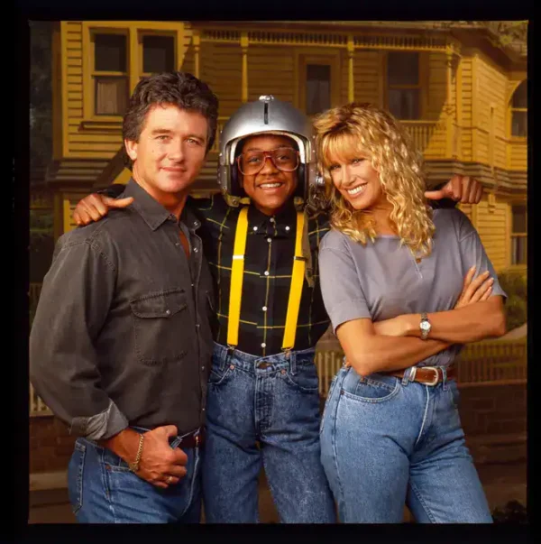 nostalgic 90s picture showing the cast of Step by Step, featuring Patrick Duffy, Suzanne Somers, and Jaleel White as Steve Urkel in his iconic suspenders and shiny silver helmet.