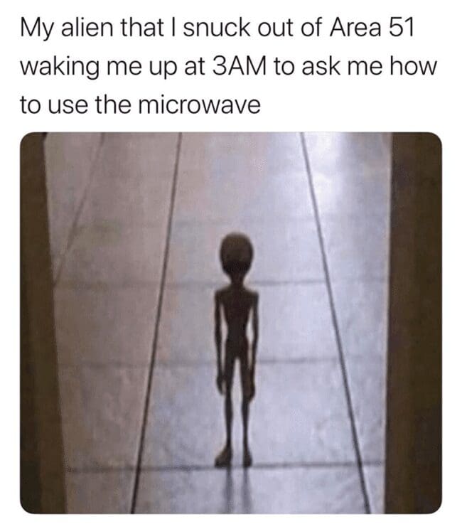 A slender alien figure standing in a hallway asking how to use the microwave.