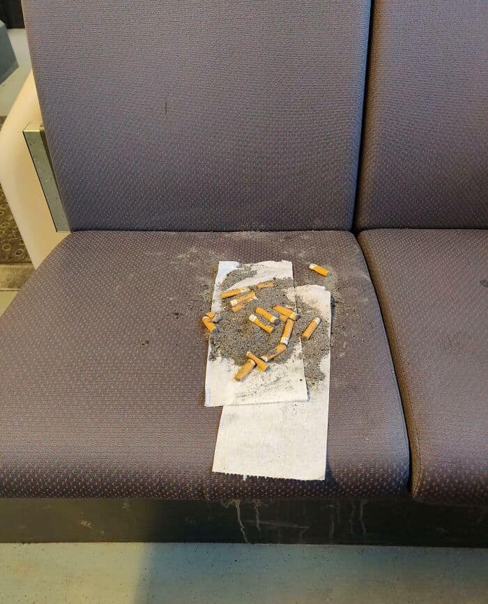 shocking display of disrespect shows cigarette butts and ash smeared across a cloth bus seat, a common complaint regarding annoying people on public transit