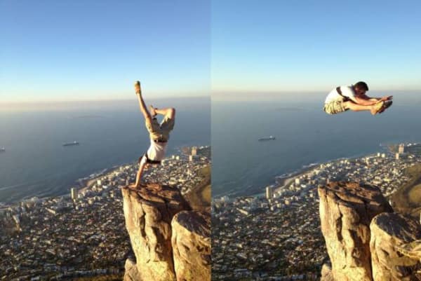 death-defying bad idea meme showing a two-panel sequence of a man performing a handstand on a tiny rock spire high above a city, followed by him leaping into mid-air over the massive drop.