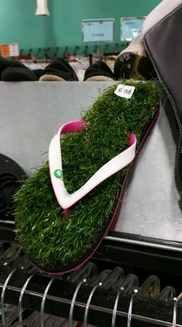 A pair of weird fashion sandals found at a thrift shop: white and pink flip-flops where the entire footbed is covered in a thick, lush layer of artificial green grass.