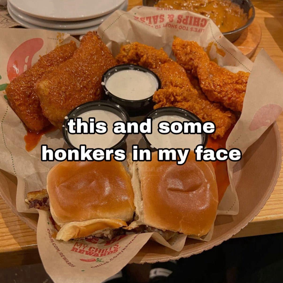completely unfiltered classic meme showing a delicious basket of Chili's chicken crispers and sliders, paired with a wildly blunt caption demanding the food and some heavy affection, a staple of unhinged old memes.