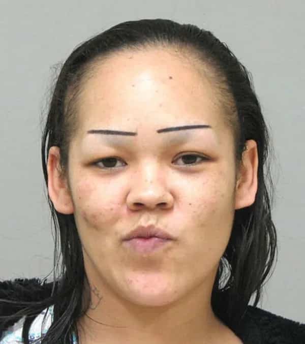 with short horizontal line eyebrows drawn high above her natural brow bone area.