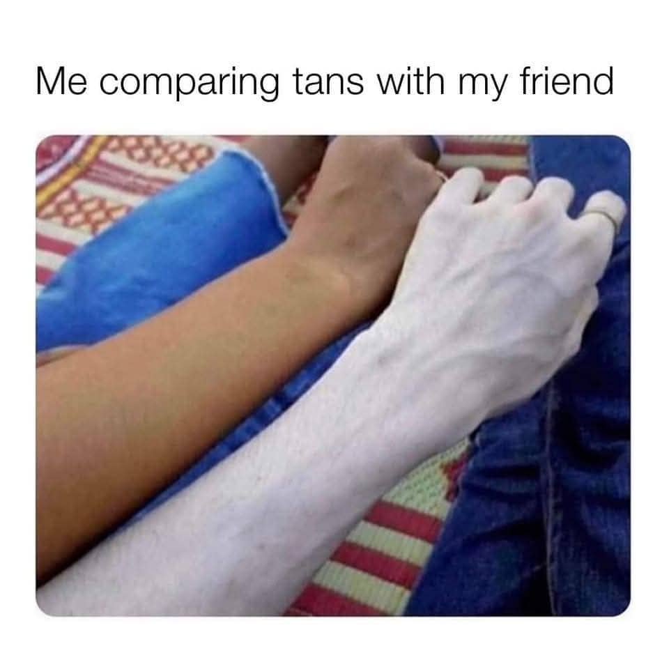 Two people comparing skin tones where one arm is extremely pale with visible blue veins.