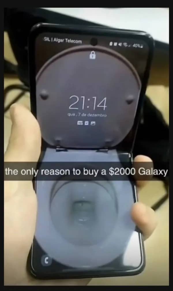 Hand holding a Samsung Galaxy Z Flip phone with a wallpaper shaped like a toilet.
