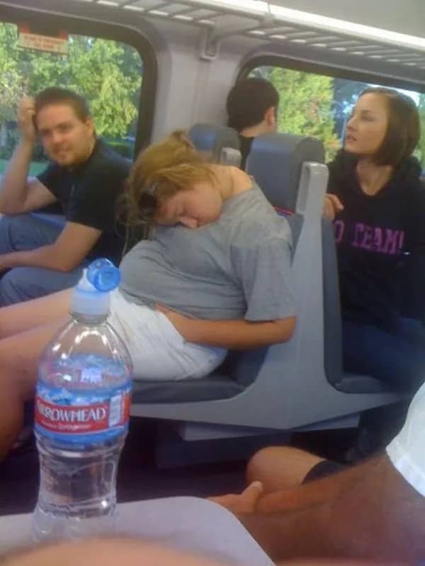 Optical illusion of a sleeping woman on a bus appearing to have a giant head.