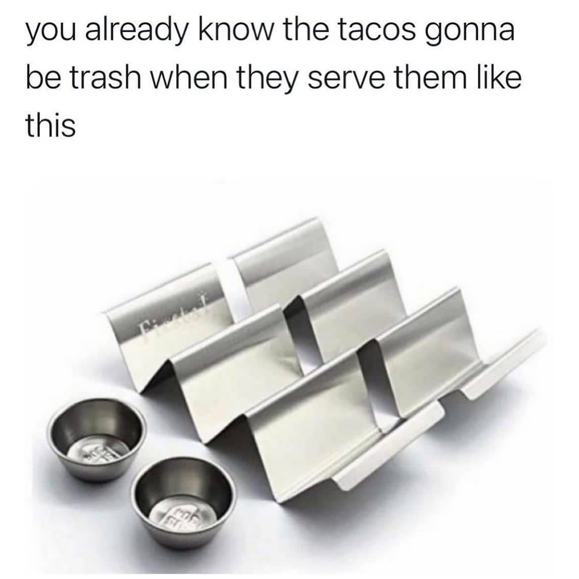 A photo of metal taco holder stands used as a sign that the restaurant's tacos are mediocre.