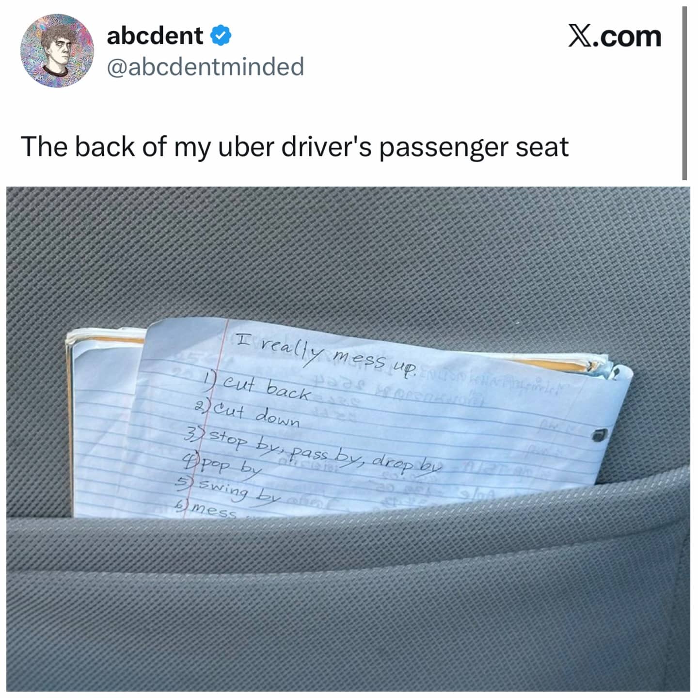 Notebook in the back of an Uber seat containing a handwritten list of common English idioms.