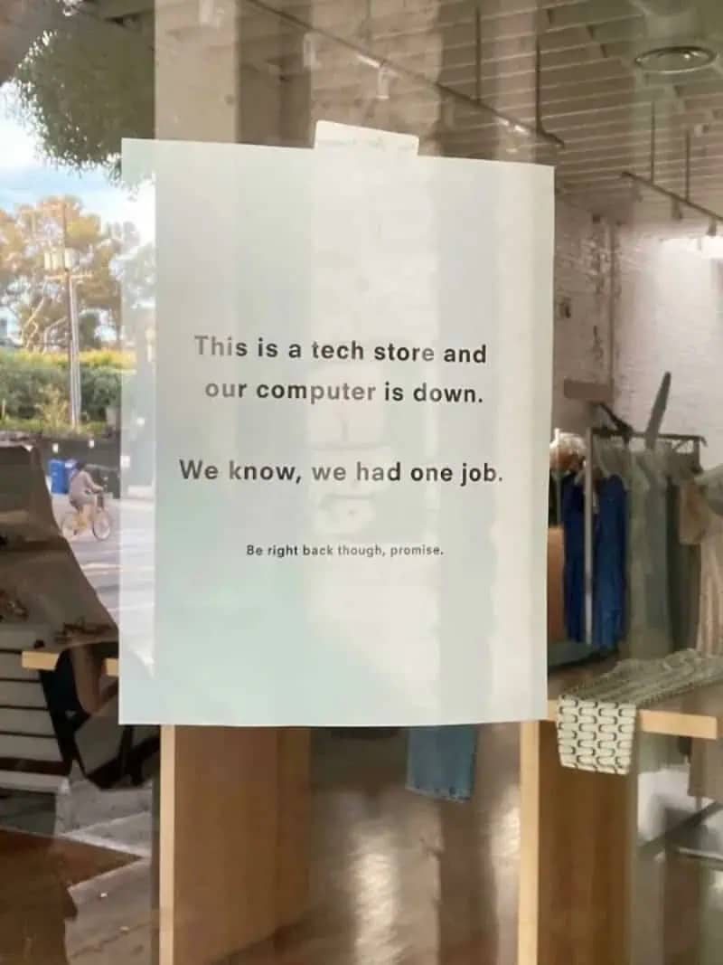 Sign on a tech store window stating their computer is down and they had one job.