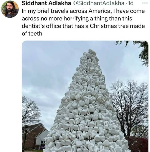 Large outdoor Christmas tree sculpture made entirely of white molar teeth at a dentist's office.
