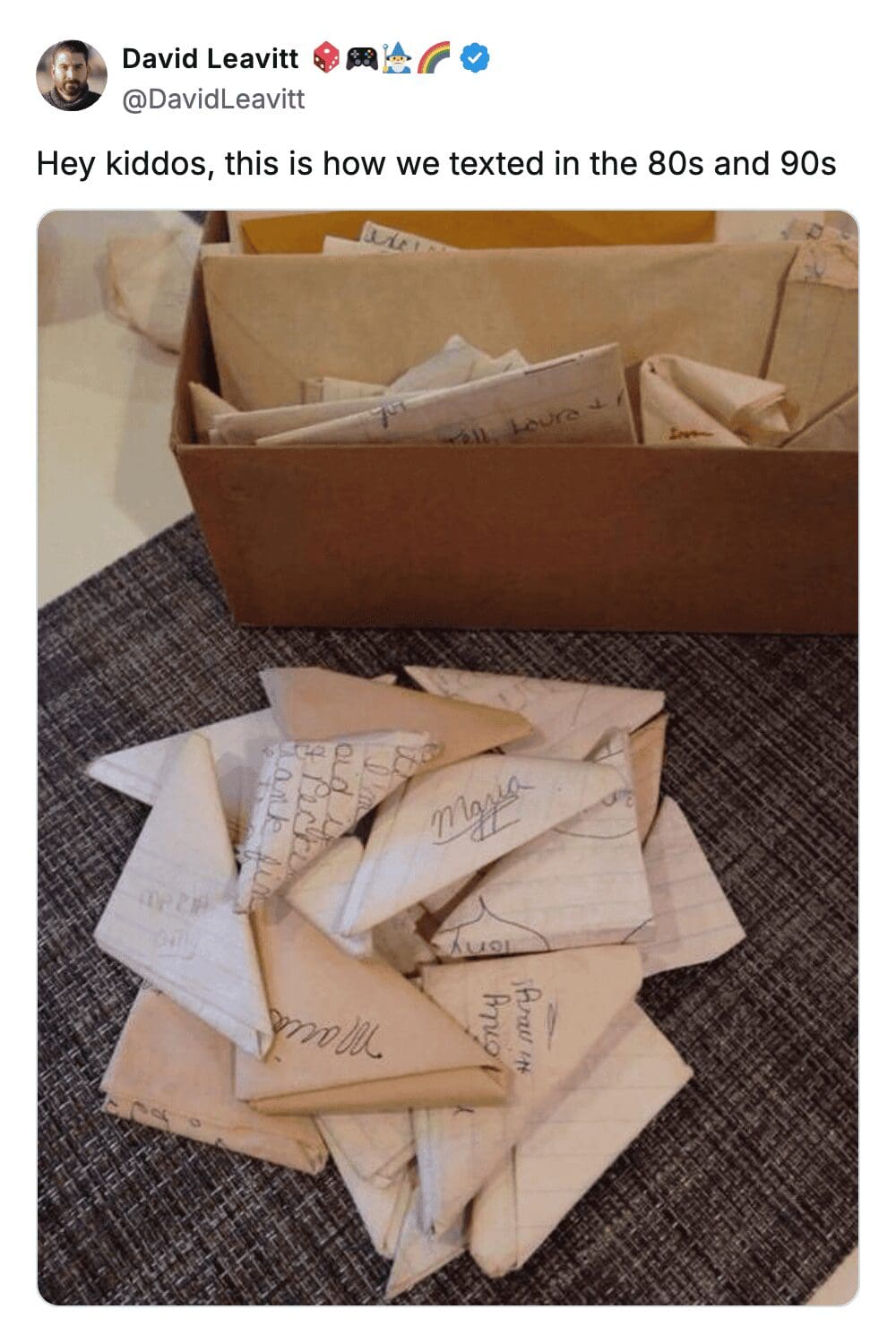 A nostalgic gen x meme showing a cardboard box completely overflowing with intricately folded paper triangles, perfectly representing how kids texted each other in class during the eighties and nineties.