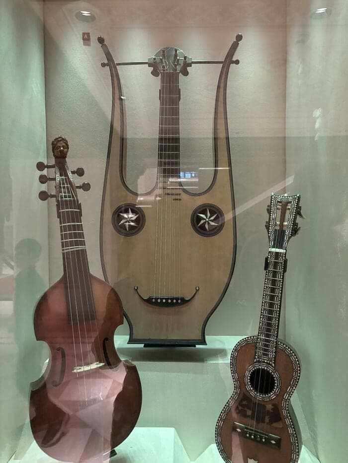 beautifully crafted historical example of inanimate objects with faces featuring an antique stringed instrument in a glass case, where sound holes and a curved bridge form a deeply happy, musical smile.