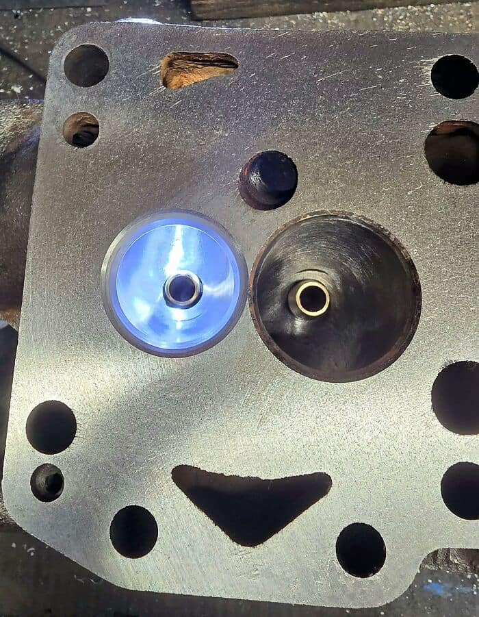A highly mechanical example of inanimate objects with faces showing a heavy metal engine block part, where circular valve openings and a triangular hole create an incredibly happy, winking robot smile.