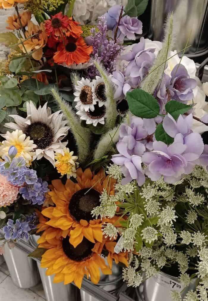optical illusion in this collection of inanimate objects with faces, showing a fuzzy white artificial flower in a bouquet that looks exactly like a screaming, spectral skull hiding among the petals.