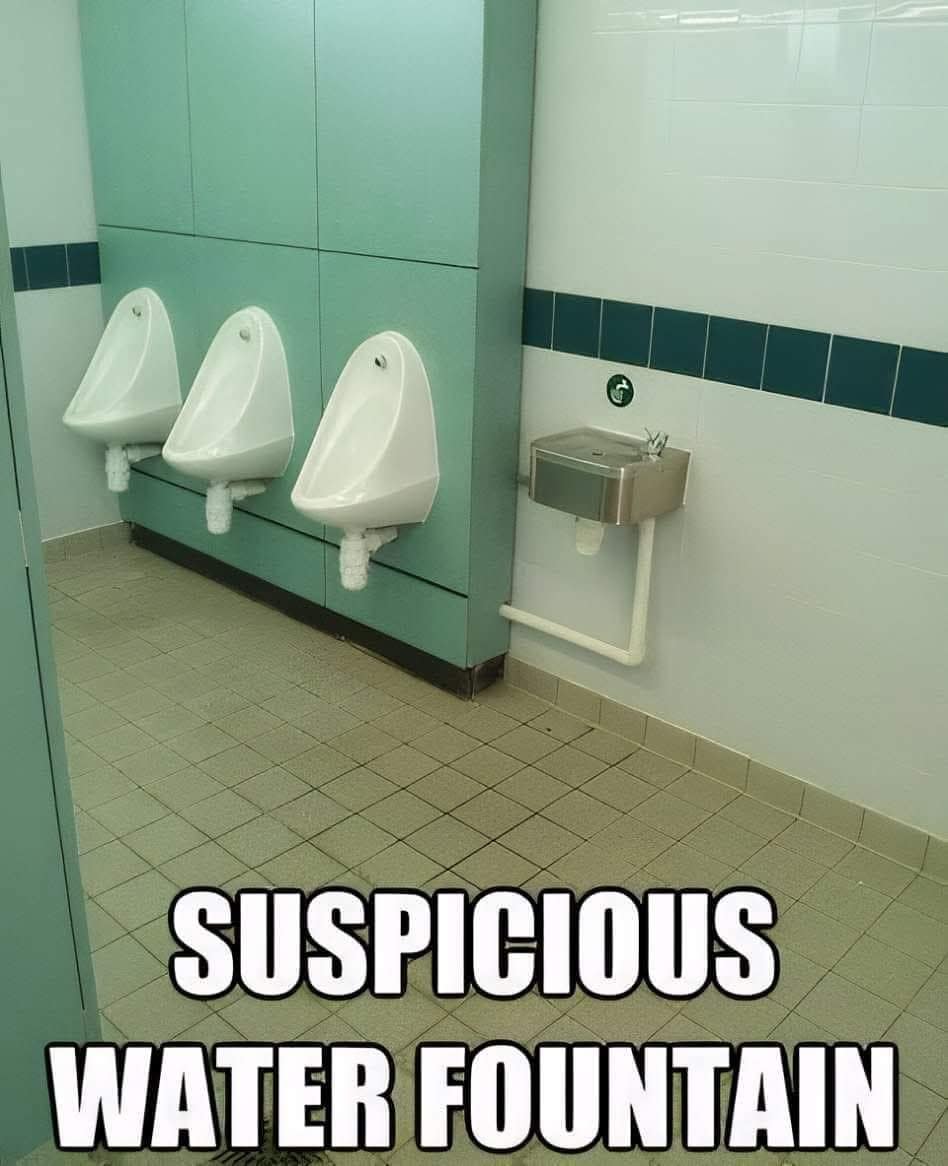funny meme of a questionable bathroom design where a standard water fountain is installed directly next to a row of urinals, labeled as a "SUSPICIOUS WATER FOUNTAIN."