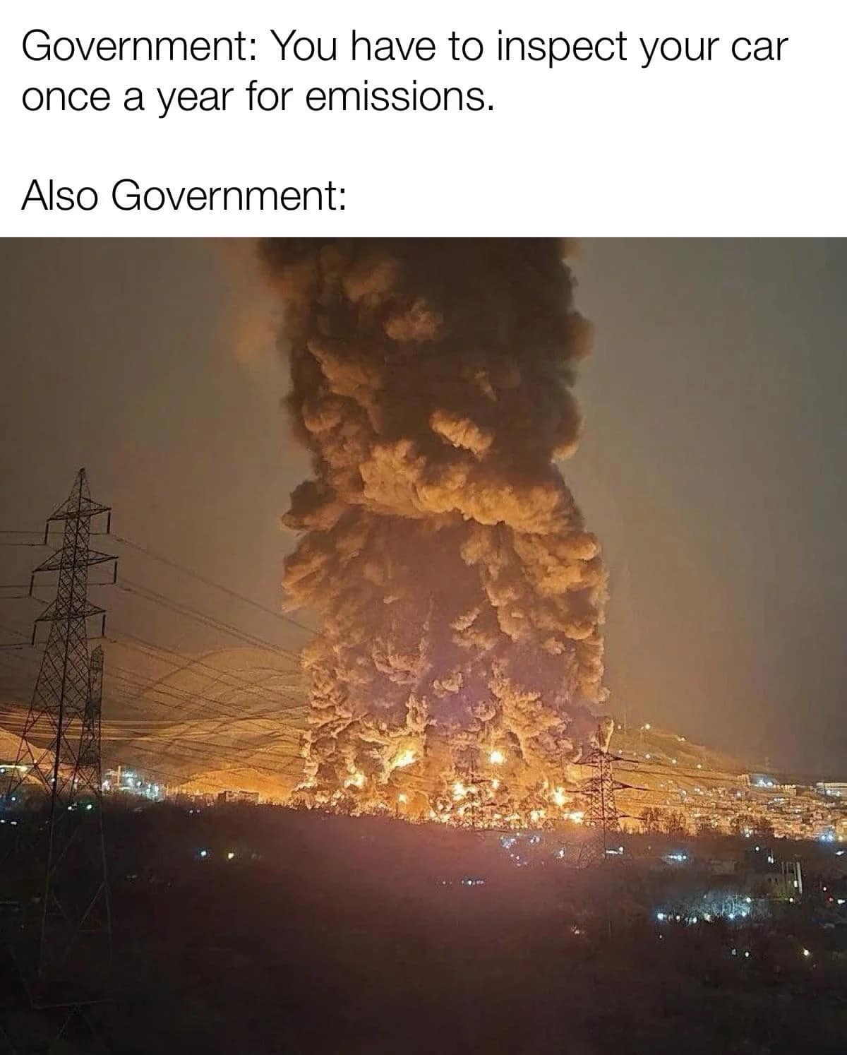 cynical environmental funny meme showing a massive, apocalyptic pillar of toxic black smoke rising from an industrial facility fire, directly contradicting the government's strict demand that regular citizens get annual car emissions tests.