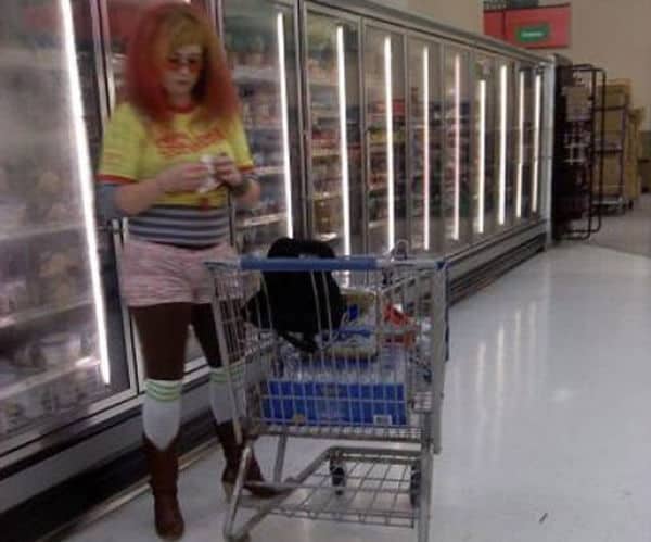 Shopper in the freezer aisle wearing a yellow shirt, pink shorts, and tall cowboy boots.