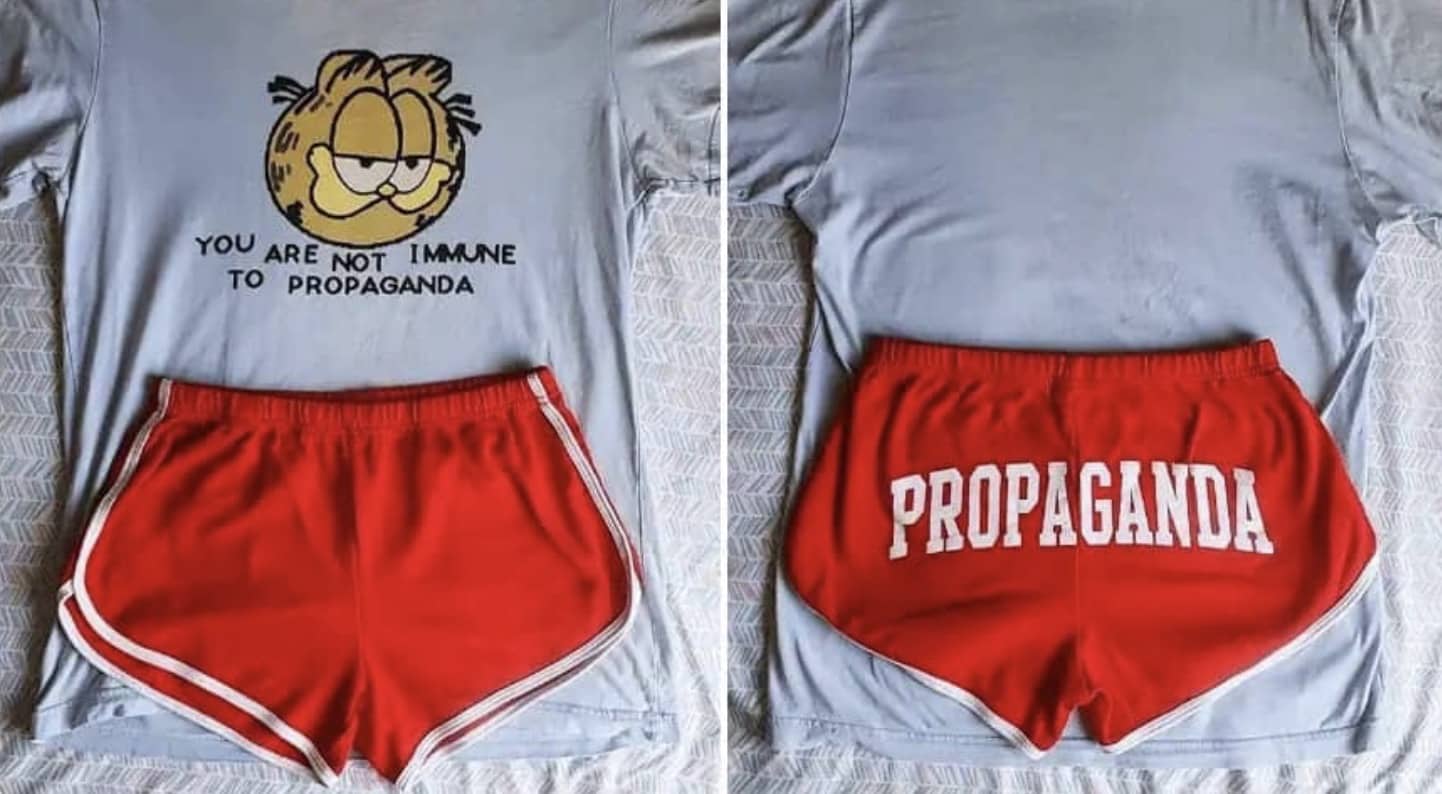 Garfield shirt stating you are not immune to propaganda paired with red shorts with propaganda printed on them.