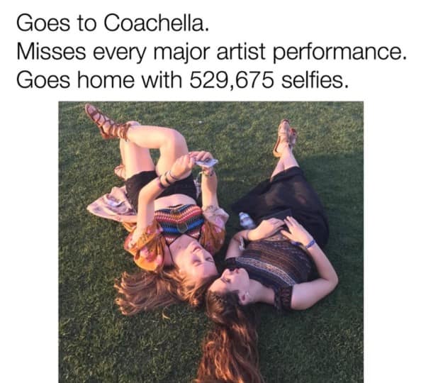 A satirical 2026 Coachella meme showing two girls lying in the grass, staring at their phones instead of the stage. The caption mocks the selfie-first culture: "Goes to Coachella. Misses every major artist performance. Goes home with 529,675 selfies."