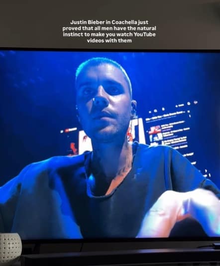 A sharp-witted Bieberchella meme showing a photo of a TV screen where Justin Bieber is performing. Behind him, a giant LED screen displays a literal YouTube interface with a sidebar of recommended videos. The text reads: "Justin Bieber in Coachella just proved that all men have the natural instinct to make you watch YouTube videos with them."