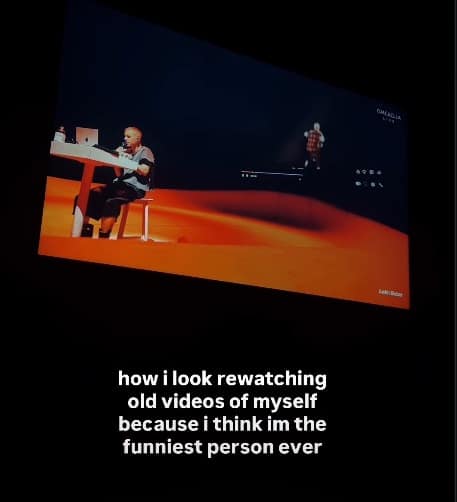 A self-deprecating Bieberchella meme showing a wide-angle shot of a living room where a TV displays Justin Bieber sitting at a desk on stage. The caption below says: "how i look rewatching old videos of myself because i think im the funniest person ever."