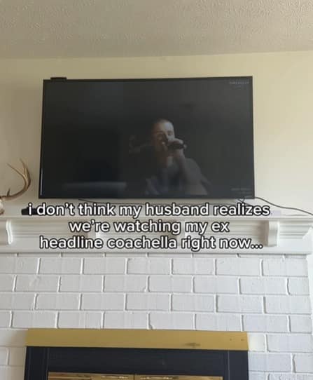 A Bieberchella meme showing a living room setup where a TV above a white brick fireplace is streaming the performance. The text overlay reads: "i don't think my husband realizes we're watching my ex headline coachella right now...", referencing the deep parasocial connection long-time fans feel toward the singer.