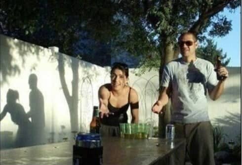 Accidentally hilarious photo where wall shadows make a casual beer pong game appear extremely inappropriate instead.