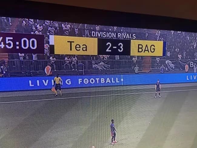 An accidentally funny sports graphic showing a division rivals soccer match score bug where the team abbreviations "Tea" and "BAG" sit perfectly side-by-side, creating a suggestive "Tea BAG" visual during the 45:00 mark.