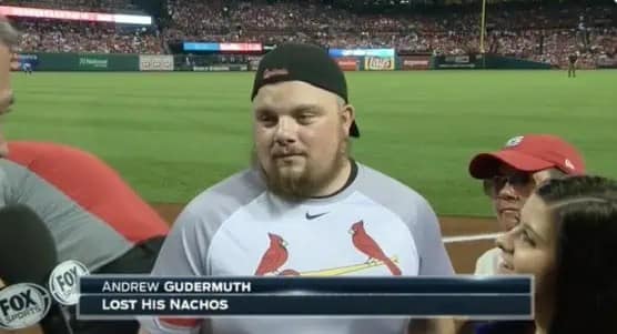 accidentally funny sports graphic from a Fox Sports broadcast of a baseball game. The lower-third graphic identifies a fan in the stands as "ANDREW GUDERMUTH," with his primary achievement listed as "LOST HIS NACHOS."