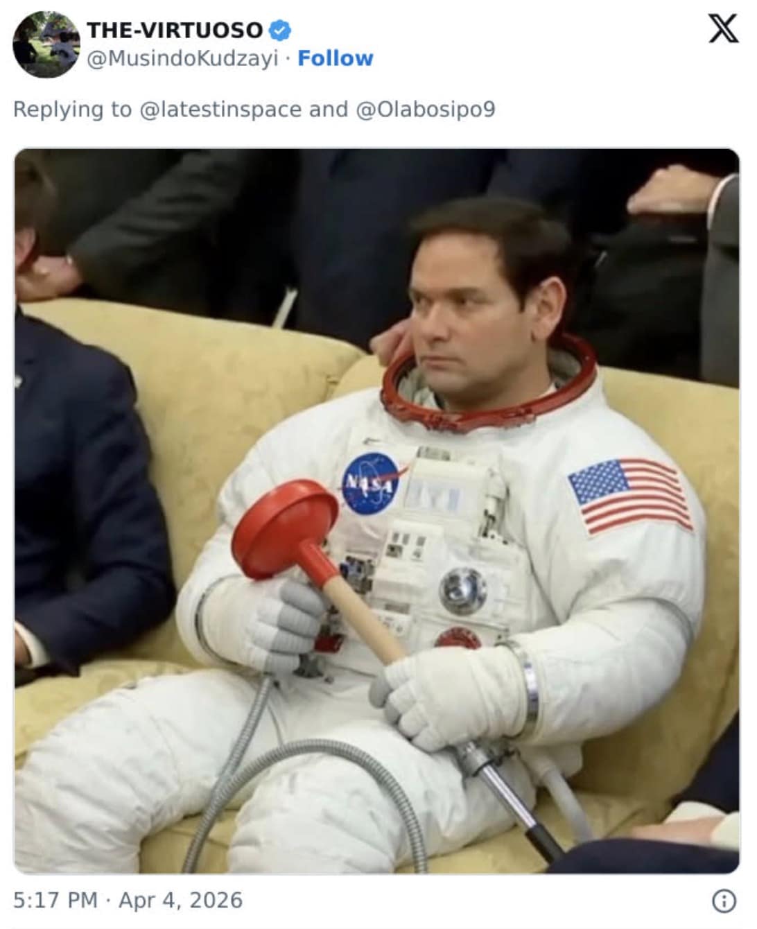 A surreal artemis 2 meme featuring a photoshopped image of a man in a full white NASA EVA suit sitting stoically on a tan couch while holding a standard red rubber toilet plunger.