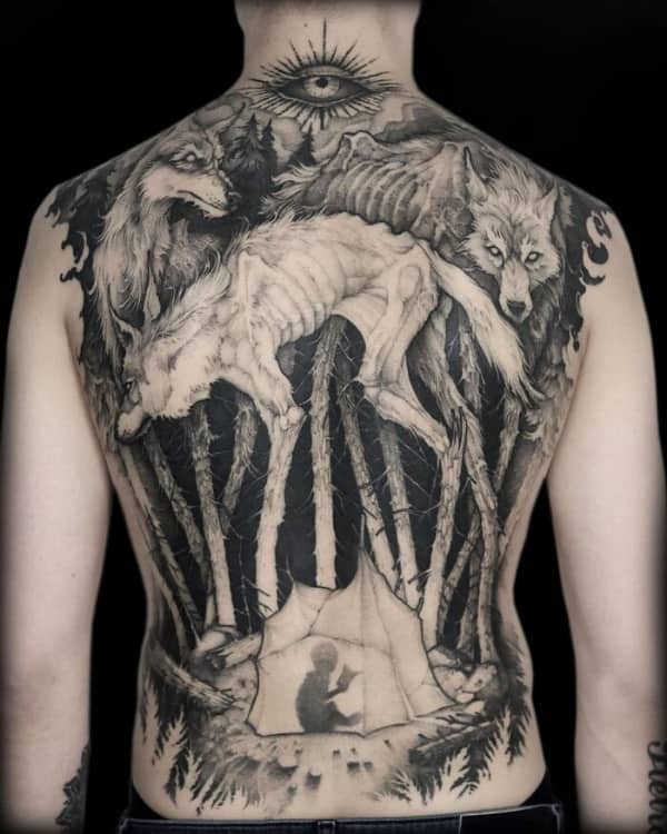 Massive full back tattoo featuring skeletal wolves, a dark forest, and a child reading in a tent.