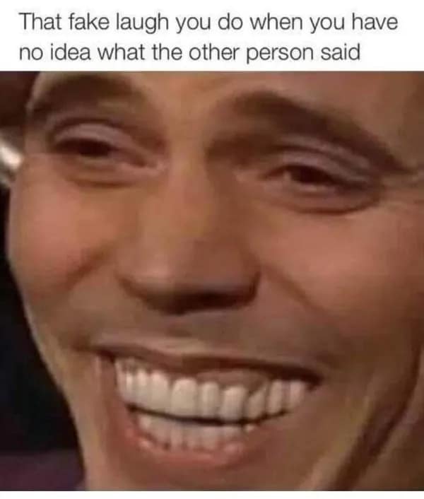 A relatable awkward meme showing a macro close-up of a man’s face frozen in a painful, wide-toothed grimace. The caption identifies it as "That fake laugh you do when you have no idea what the other person said," capturing the panic of losing the thread of a conversation.